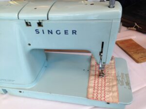 A vintage pale blue metal sewing machine.