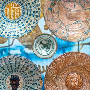 A display of richly decorated Iranian ceramic plates.