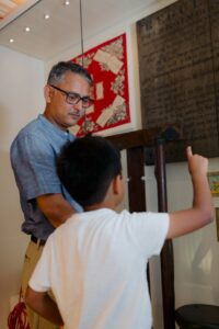 An adult and a child with medium-tone skin explore the displays at David Livingstone Birthplace.