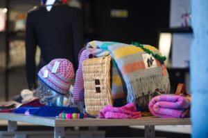 Colourful woollen hats and scarves on display in a museum shop.