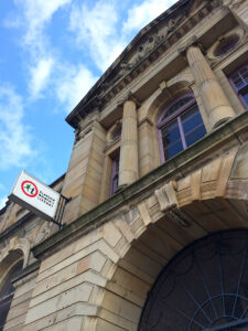 The entrance to Glasgow Women's Library. It is a yellow sandstone building with a tall neo-classical façade.