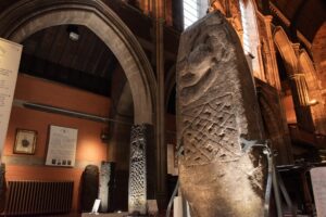Tall standing stones carved with Pictish patterns and figures on display at Govan Stones in Glasgow.