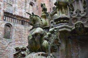 Detail of a carved stone fountain at Linlithgow Palace. It depicts a unicorn holding a shield.