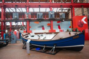 A large blue wooden boat with the name 'Katie' on display at the Scottish Maritime Museum.