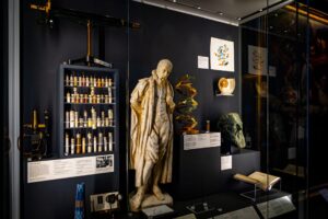 A selection of scientific artefacts, including models, statues, equipment, and books, on display in a case at Wardlaw Museum in St Andrews.