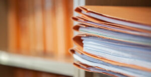 A close up of files of paper in orange covers