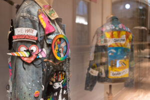 A close-up of a denim jacket covered in colourful badges and appliques.