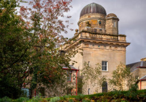 A large sandstone building with a domed copper roof.